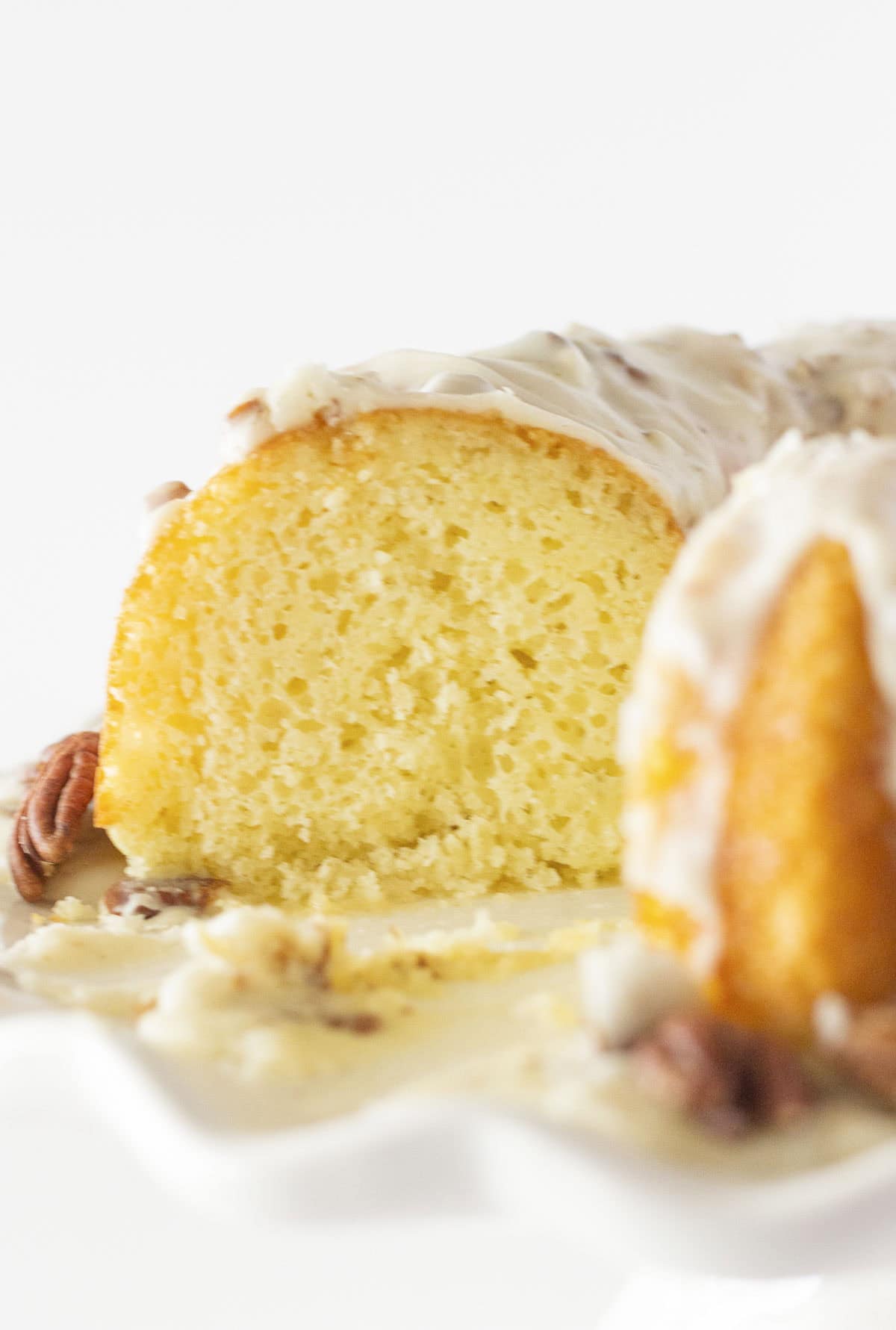 Looking at the inside of white sheet cake with pecan frosting after a slice is removed.