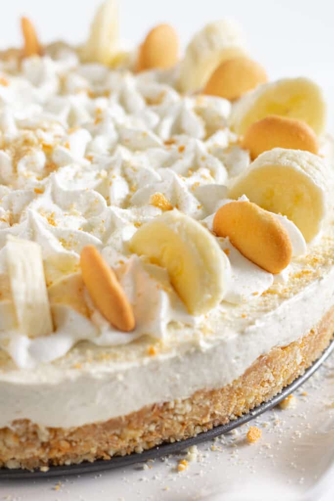 A no bake banana pudding cheesecake topped with banana slices and nilla wafers.