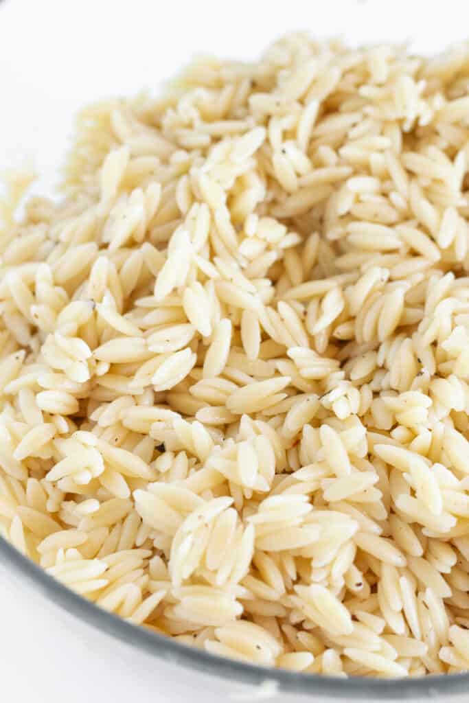 Orzo in a glass mixing bowl.