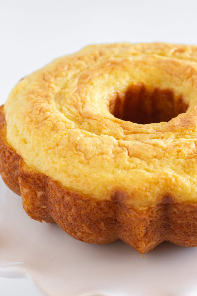 A vanilla bundt cake, inverted on a white dish.
