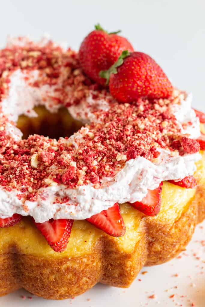 A finished strawberry crunch pound cake with fresh strawberries.