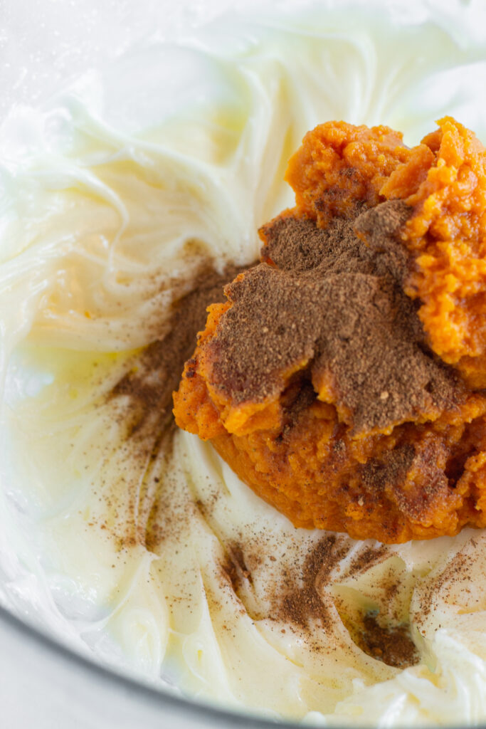 A mixing bowl full of the ingredients needed to make this pumpkin cheesecake bars recipe.