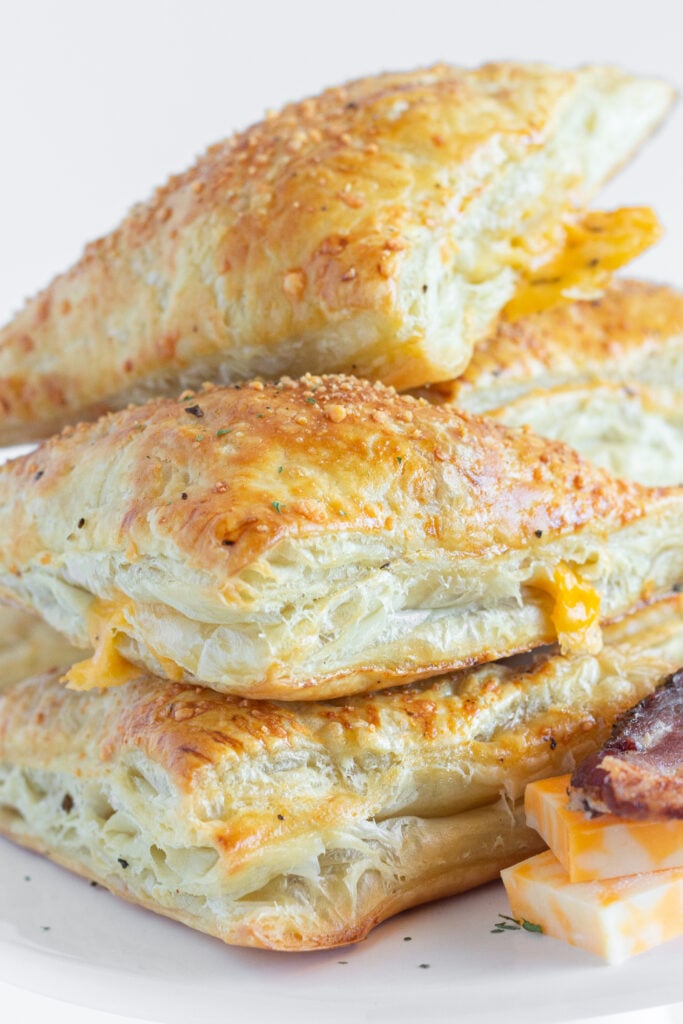 A platter of Bacon Turnovers stacked on top of each other.
