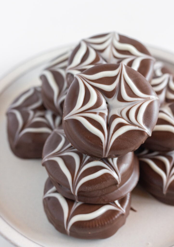 A plate of Halloween Chocolate Covered Oreos that look like spider webs.