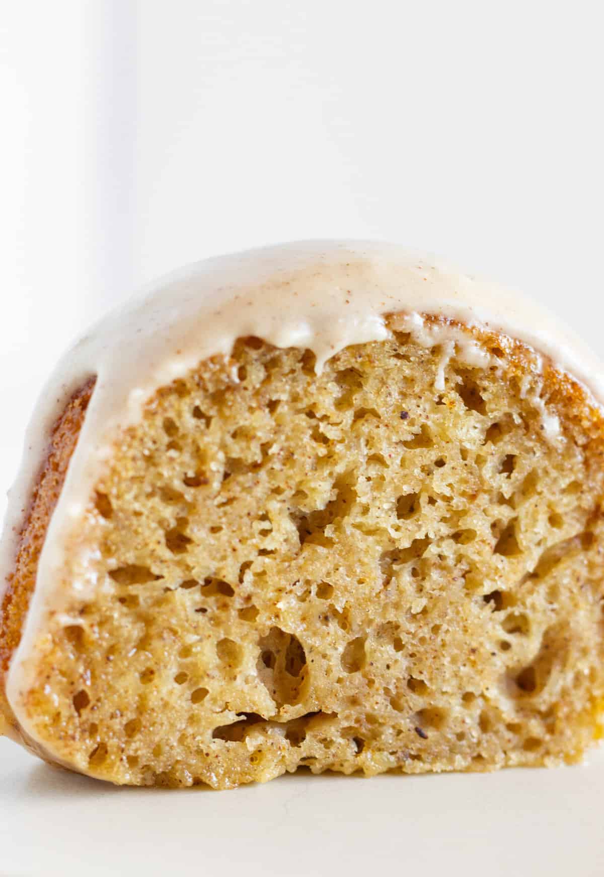 A slice of Spice Bundt Cake with maple glaze on a plate and ready to serve.