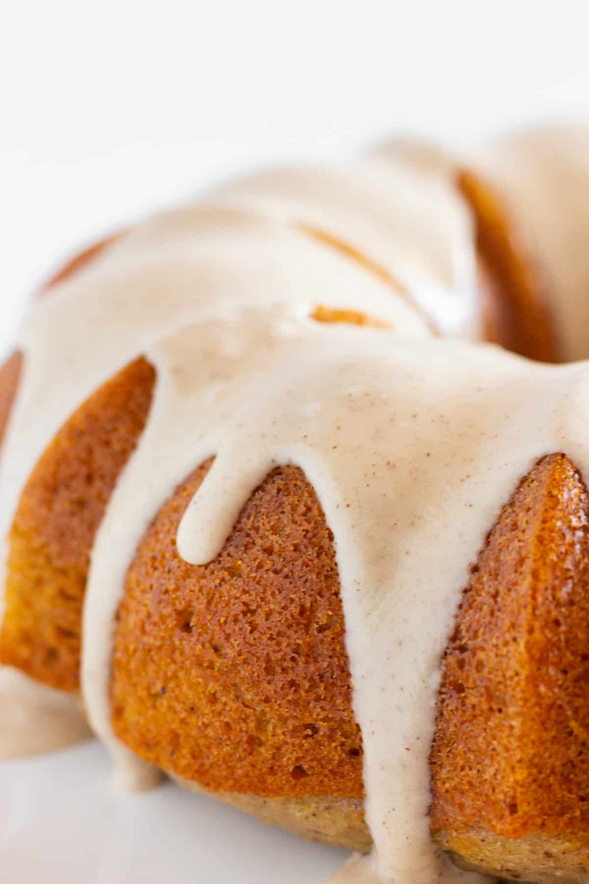 An up close photo of Spice Bundt Cake where you can see the cinnamon flecks in the maple glaze.