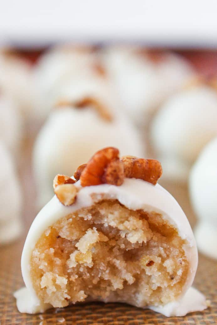 A tray of pecan sandies truffles with a bite taken out of one.