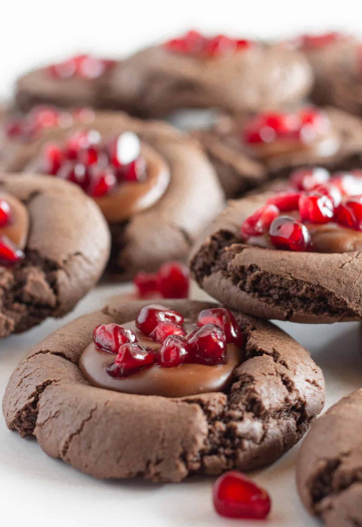 Chocolate cookies with chocolate ganache filling and pomegranate seeds.