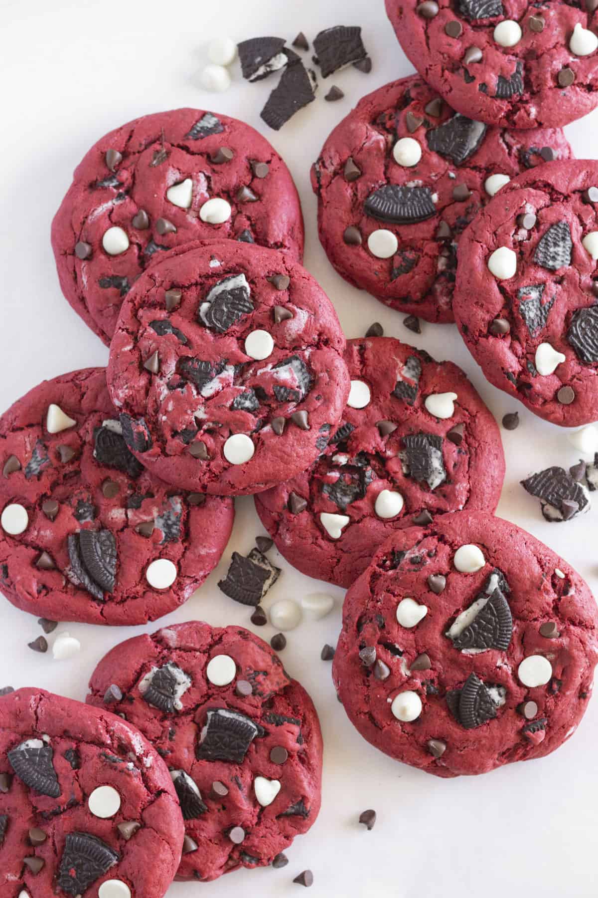Looking down on 10 Red Velvet Oreo Cookies that are deep red in color with chunks of Oreo cookies and chocolate chips.
