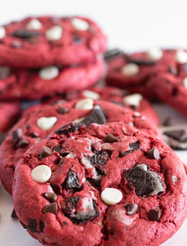 Red Velvet Oreo Cookies filled with Oreo cookie chunks and chocolate chips are leaned on each other.