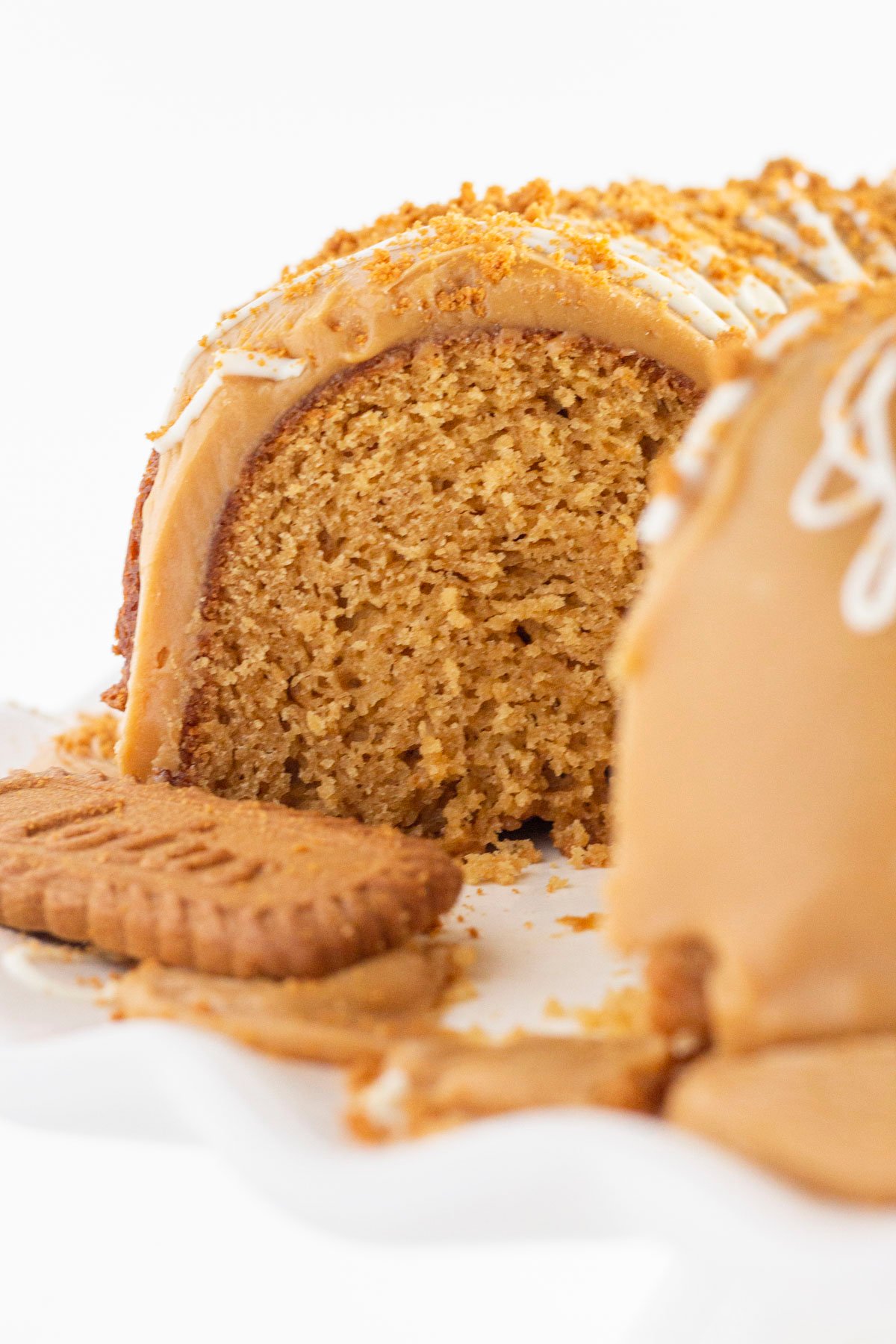 A cookie butter bundt cake with a piece cut out and looking into the middle of the cake.