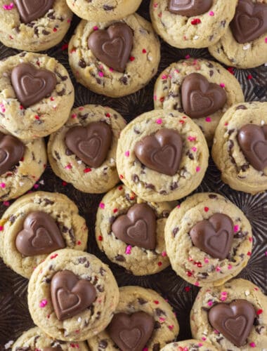 A tray full of Valentine's Chocolate Chip Cookies with heart sprinkles and a chocolate heart.