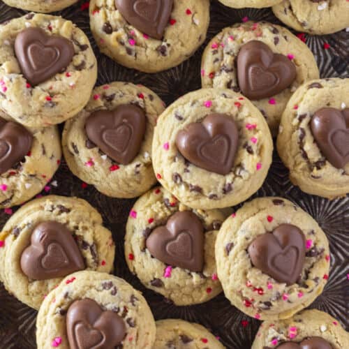 A tray full of Valentine's Chocolate Chip Cookies with heart sprinkles and a chocolate heart.