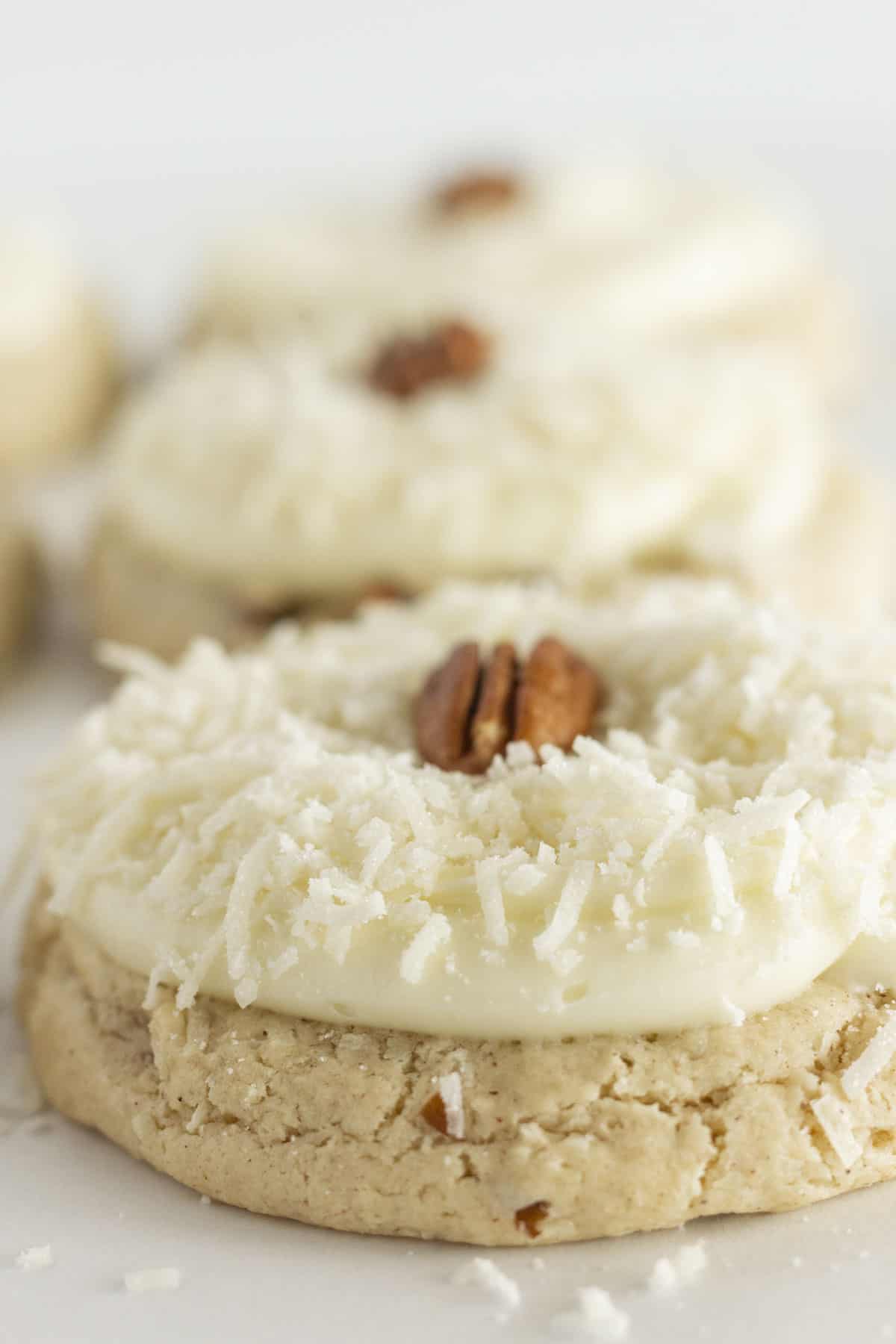 6 large Coconut Pecan Cookies with cream cheese frosting.