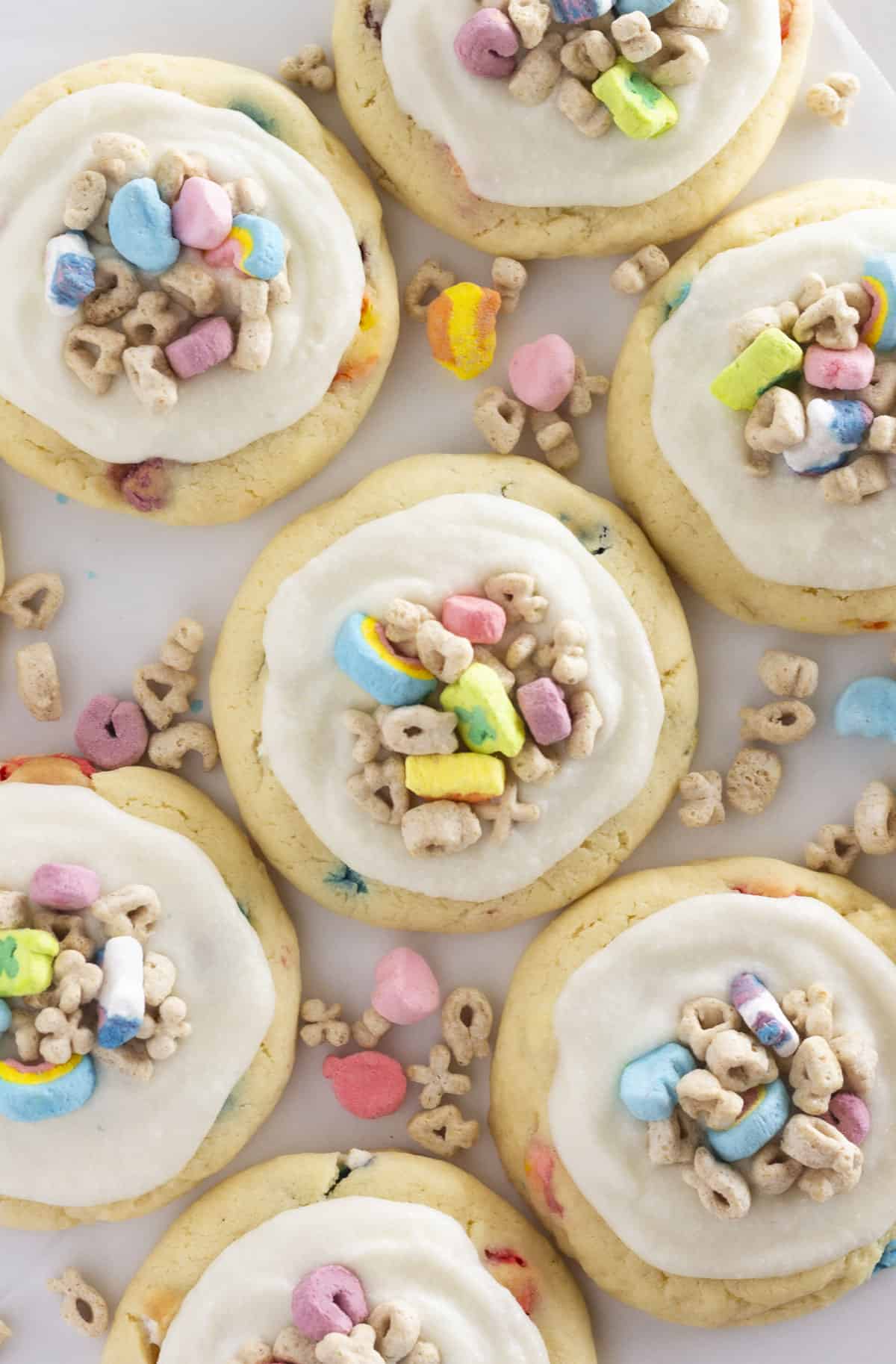 A photo looking over the top of a dozen Lucky Charms Cookies with cereal milk and cereal on top.