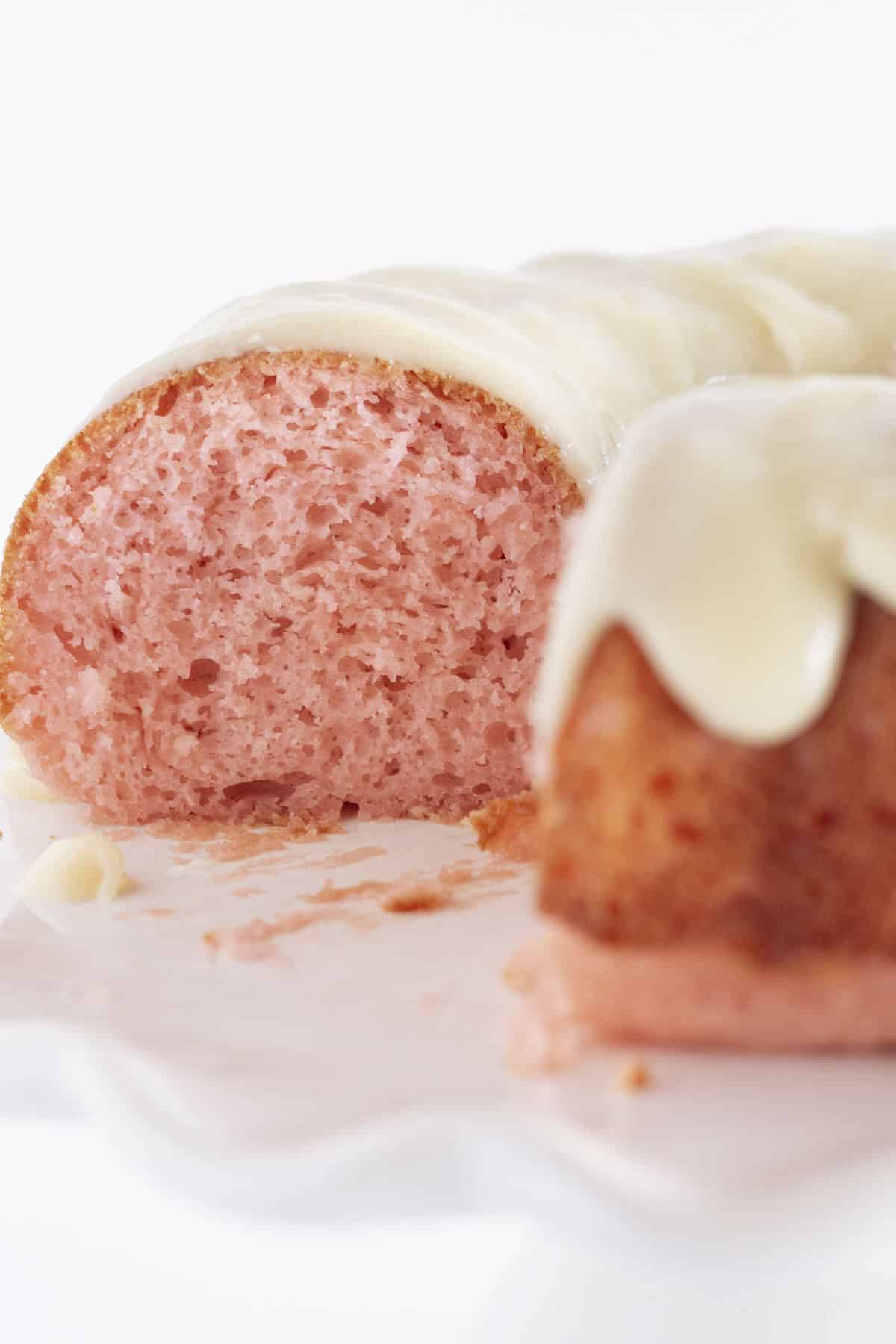 A pink velvet bundt cake looking into the middle of the cake after a slice is taken out.