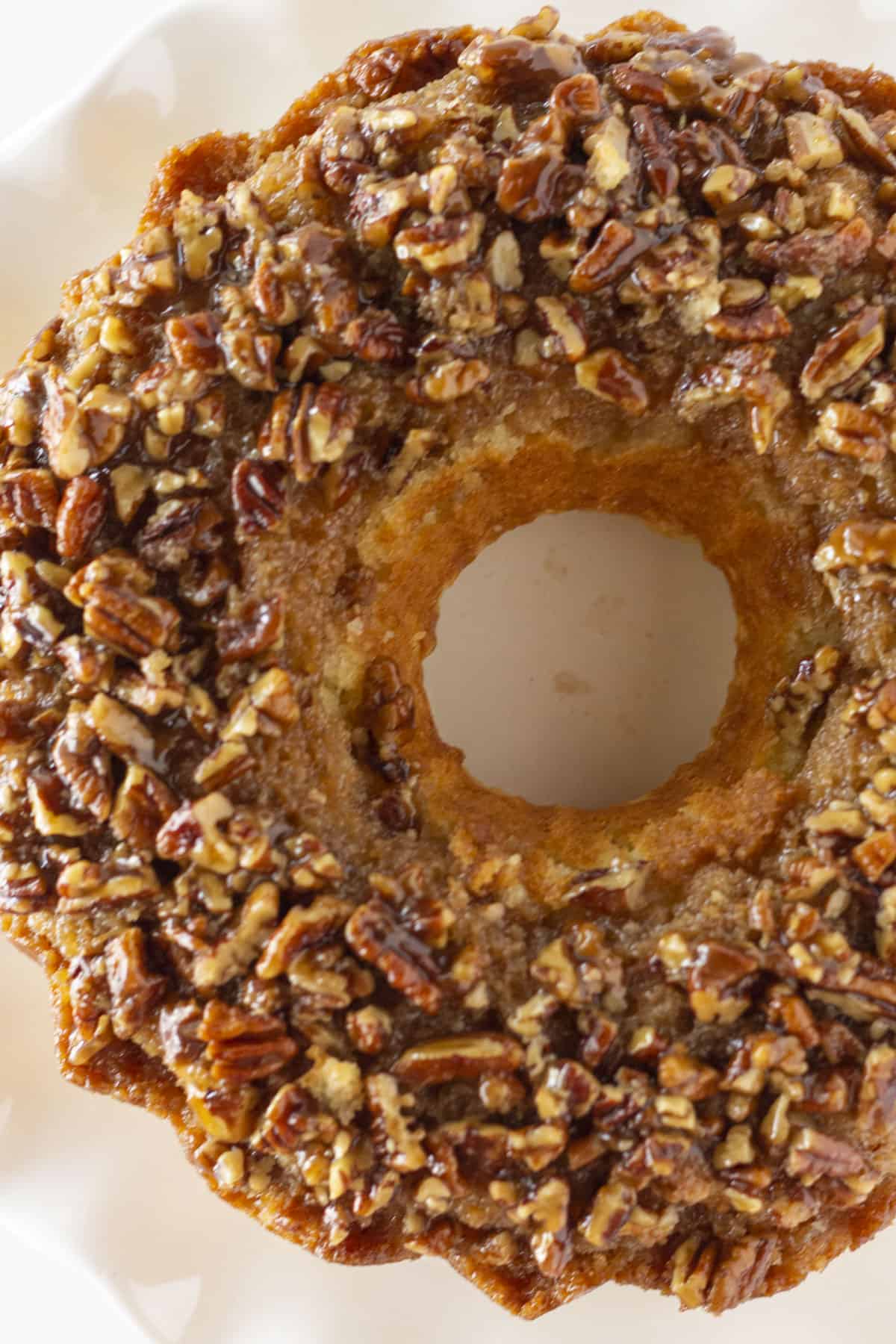 Looking down onto a pecan upside down cake on white cake plate.