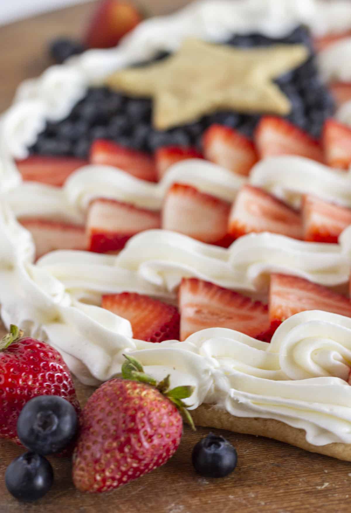 A close up photo of a flag fruit pizza with fresh fruit.