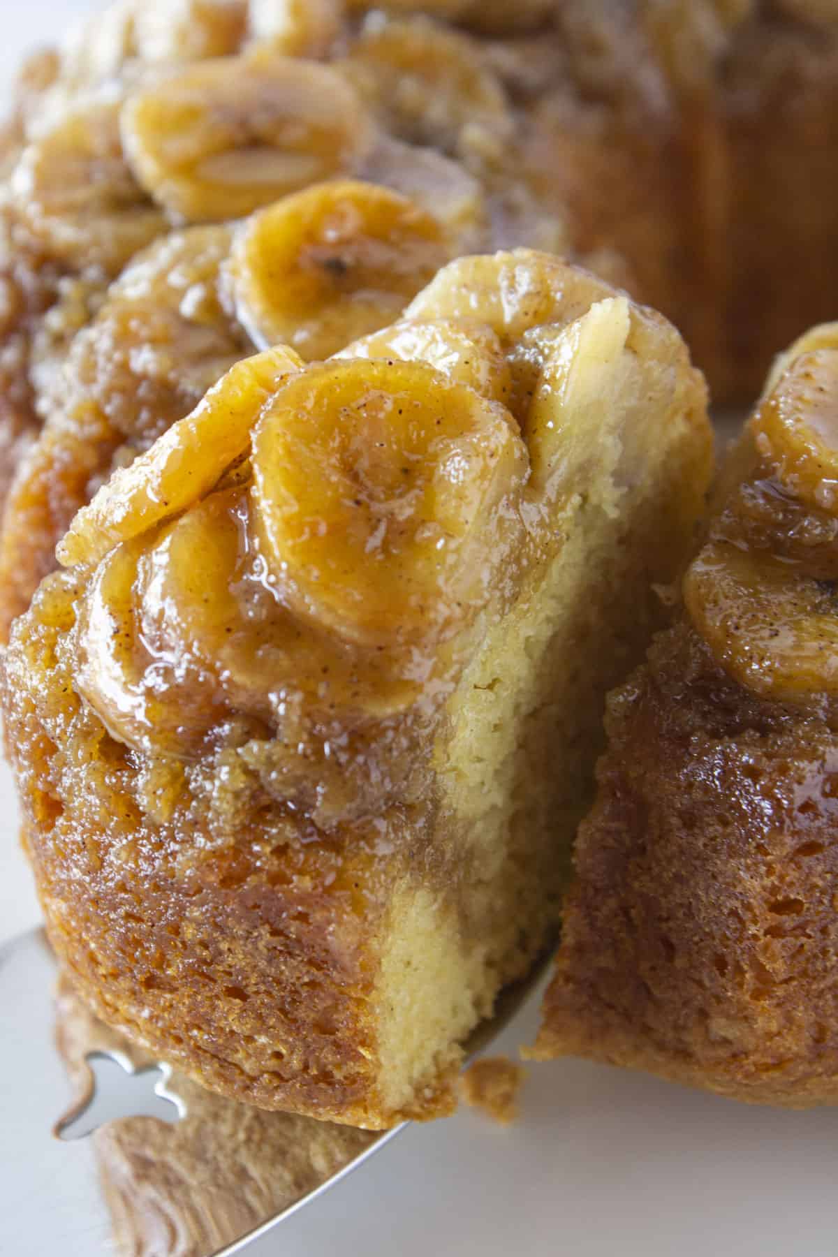 A close up photo of serving a slice of banana upside down cake.