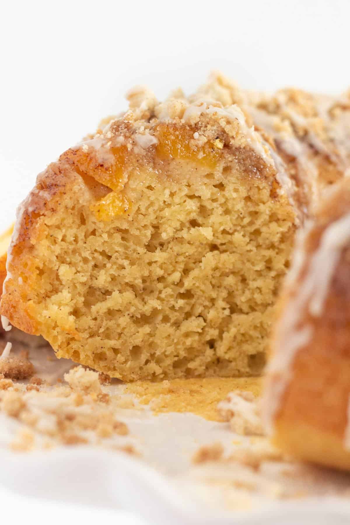 A look inside a peach cobbler bundt cake with peaches and crumb topping.