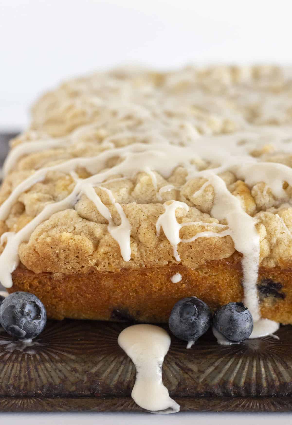 A fresh blueberry muffin cake with a drizzle of glaze.