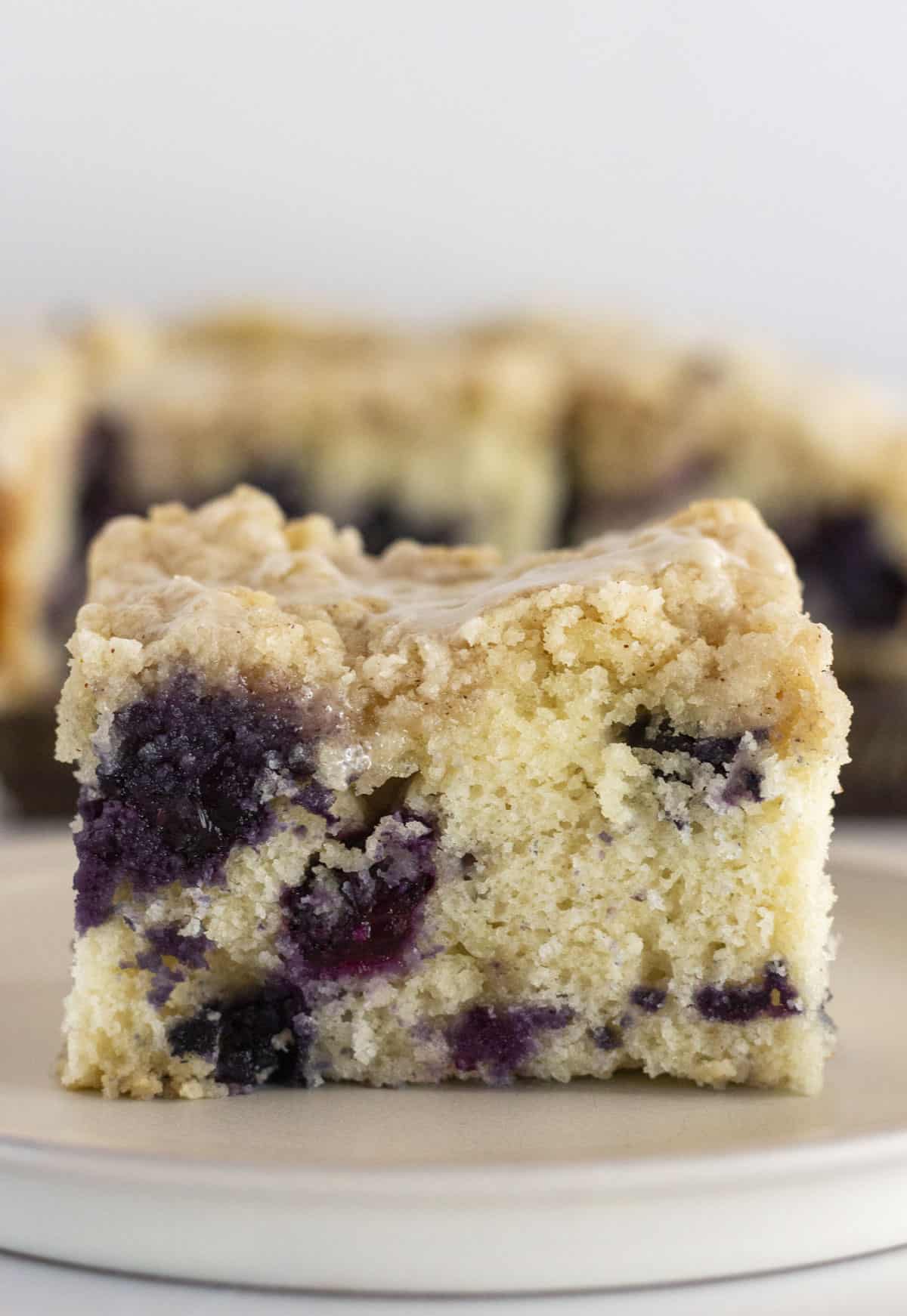 A piece of blueberry muffin cake on a plate and ready to serve.