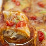 Serving frozen burrito casserole with a spoon.
