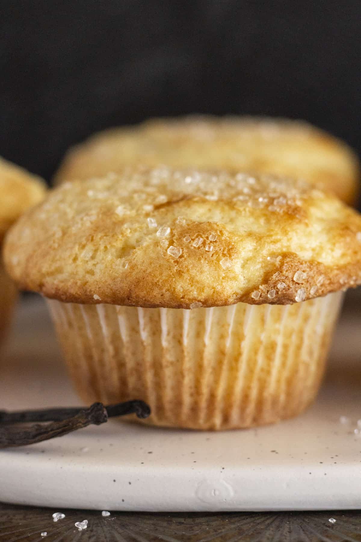 A close up photo of a moist and delicious bakery style vanilla muffin.