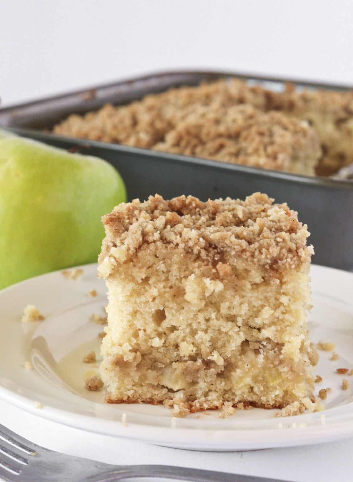 Serving a slice of apple crumb cake from the pan.