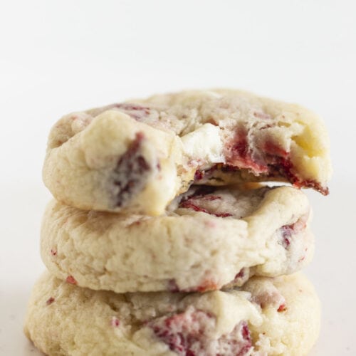 Three strawberry cream cheese cookies stacked on each other.