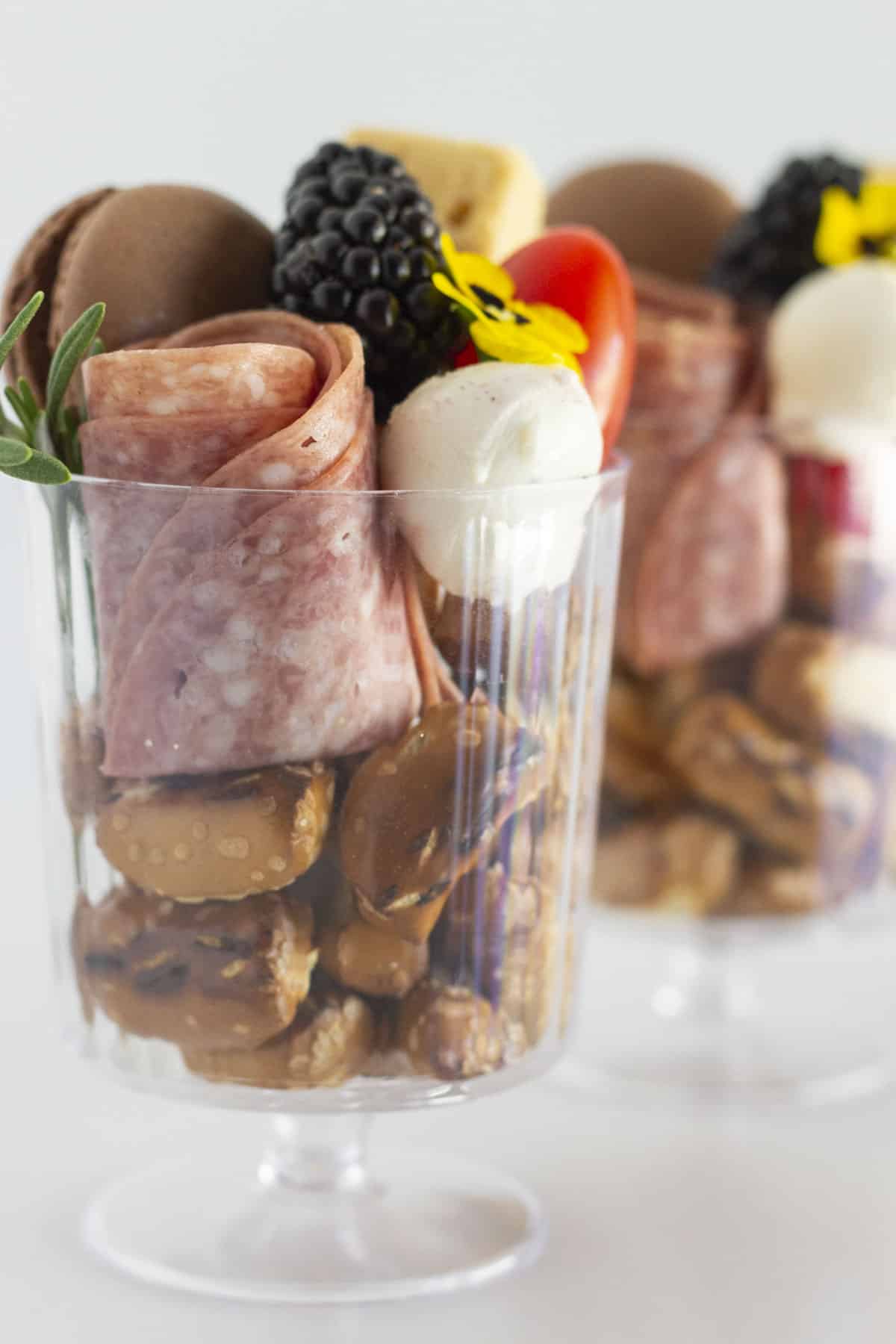 Charcuterie Cups filled with small food items and in a clear cup.
