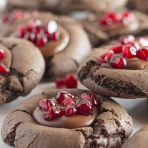 Chocolate cookies with chocolate ganache filling and pomegranate seeds.