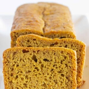 A loaf of pumpkin bread with two slices.