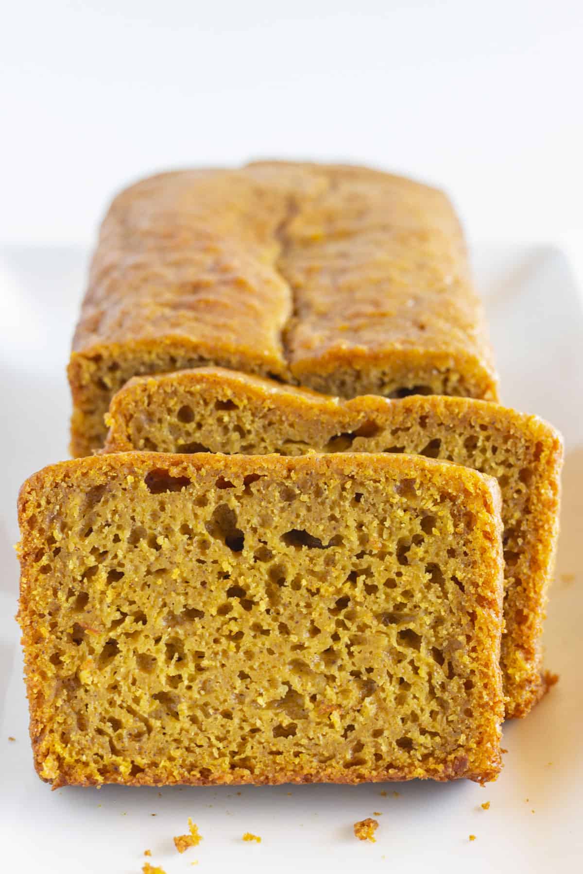 A loaf of pumpkin bread with two slices.