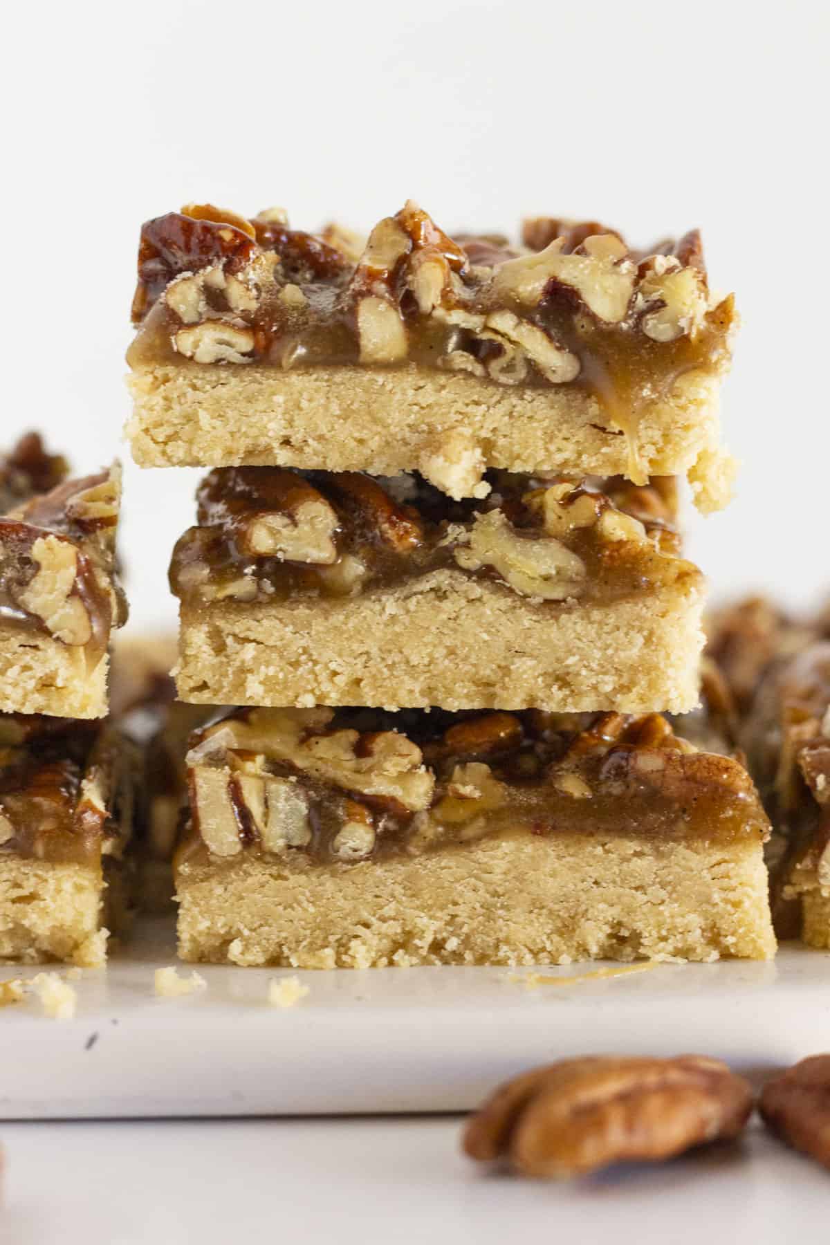 Pecan Shortbread Bars stacked on top of each other on a white plate.