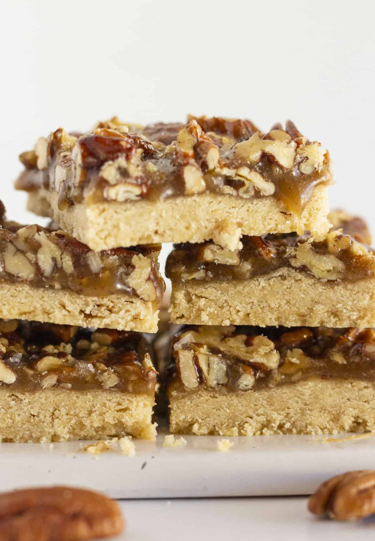 Baked pecan shortbread bars on a white plate for serving.