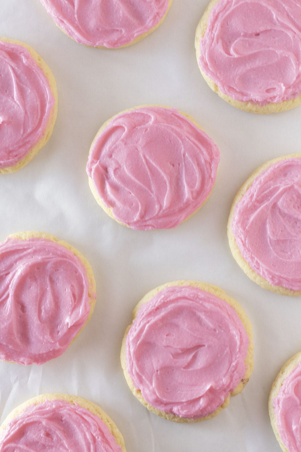 Looking down on chilled sugar cookies with pink frosting.