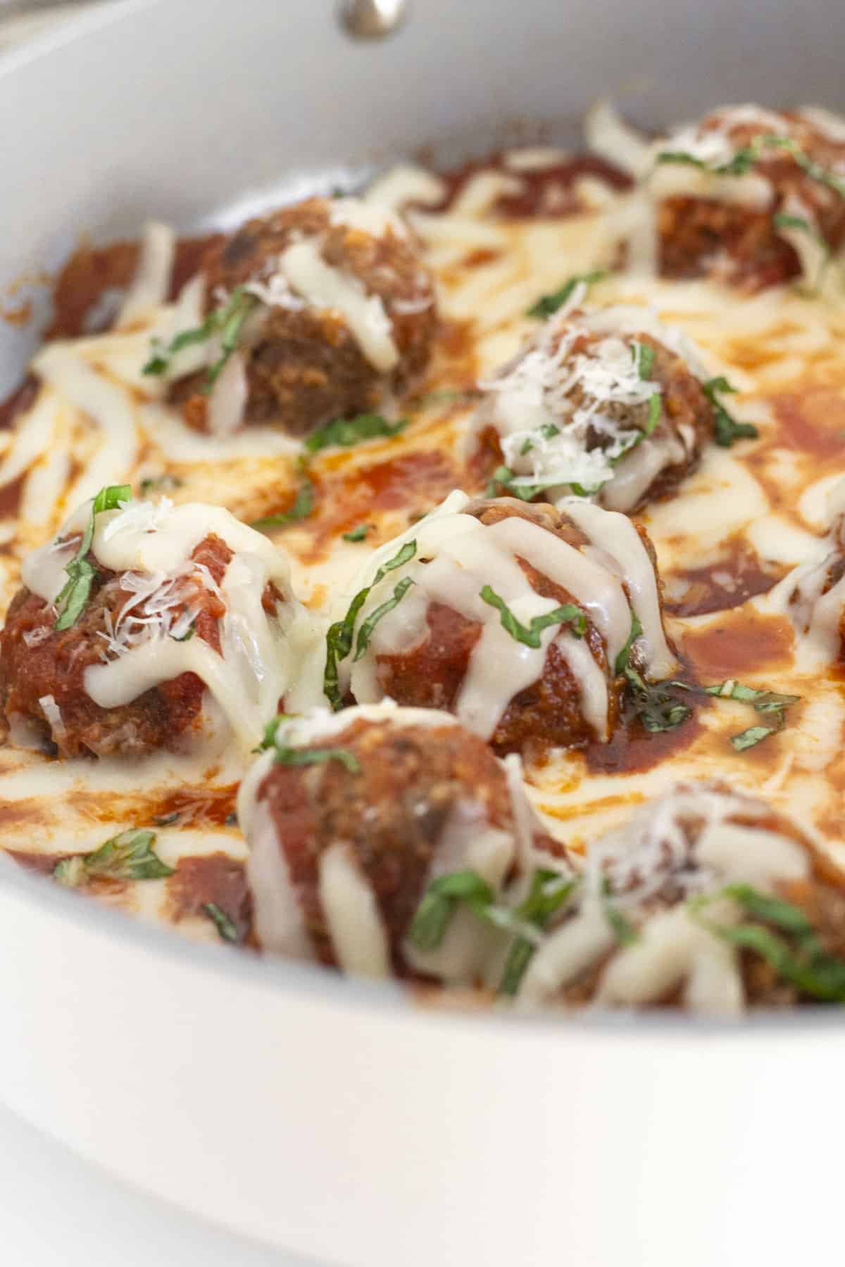 Finished meatball skillet with parmesan and basil.