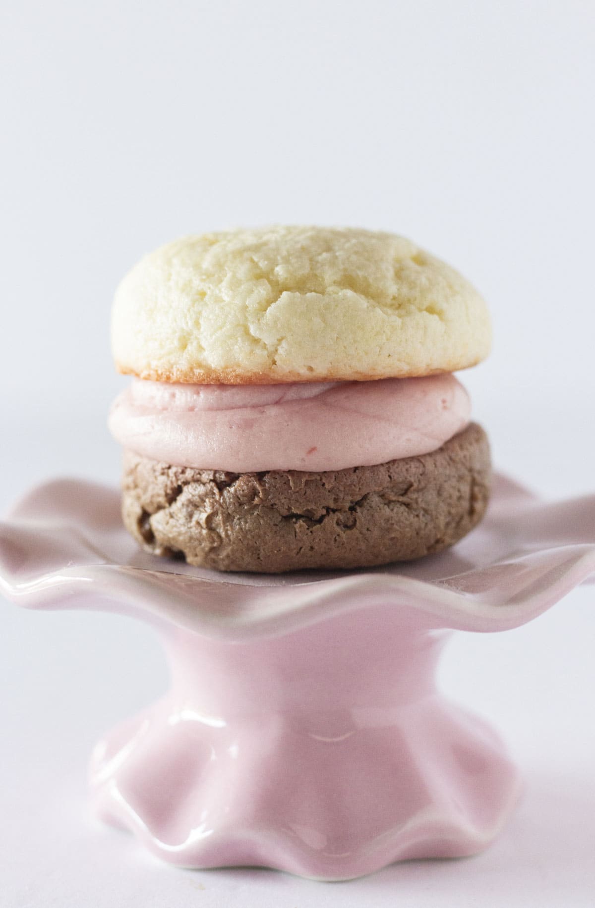 One Neapolitan sandwich cookie on a pink plate.