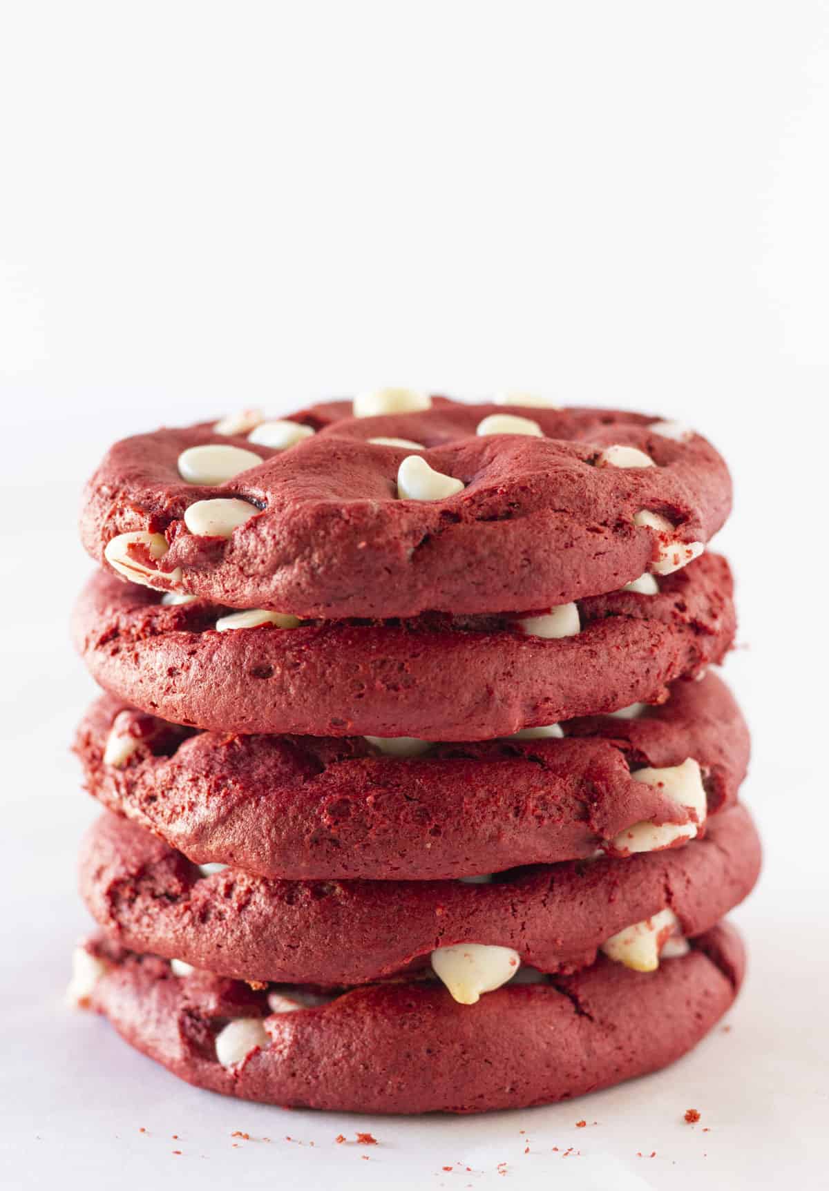 Red velvet cookies with white chocolate chips stacked on each other.