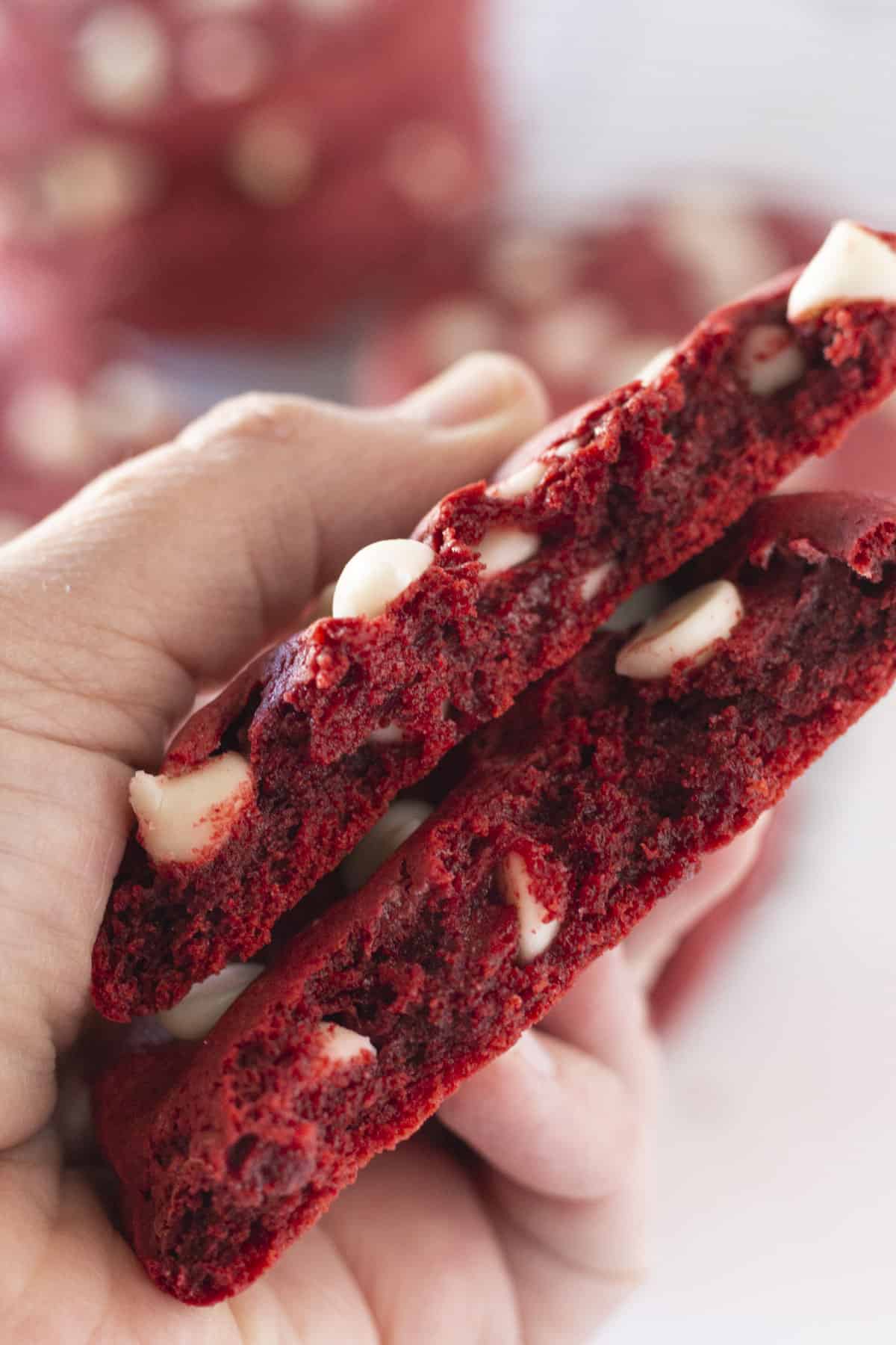 A red velvet cookie with white chocolate chips broke in half.