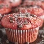 Red Velvet Muffins on a dark tray with powdered sugar and chocolate chips.