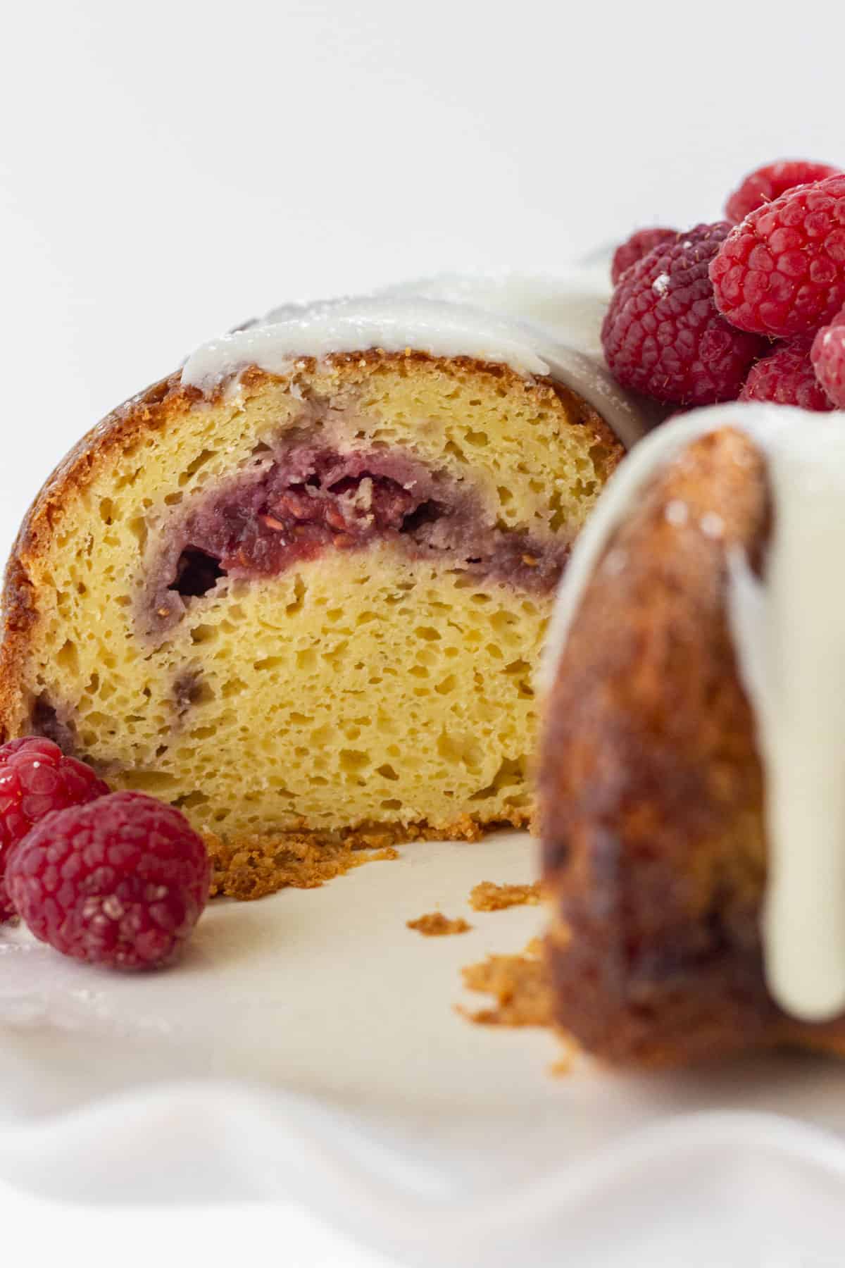 Looking in the inside of a white chocolate raspberry cake with raspberry filling.