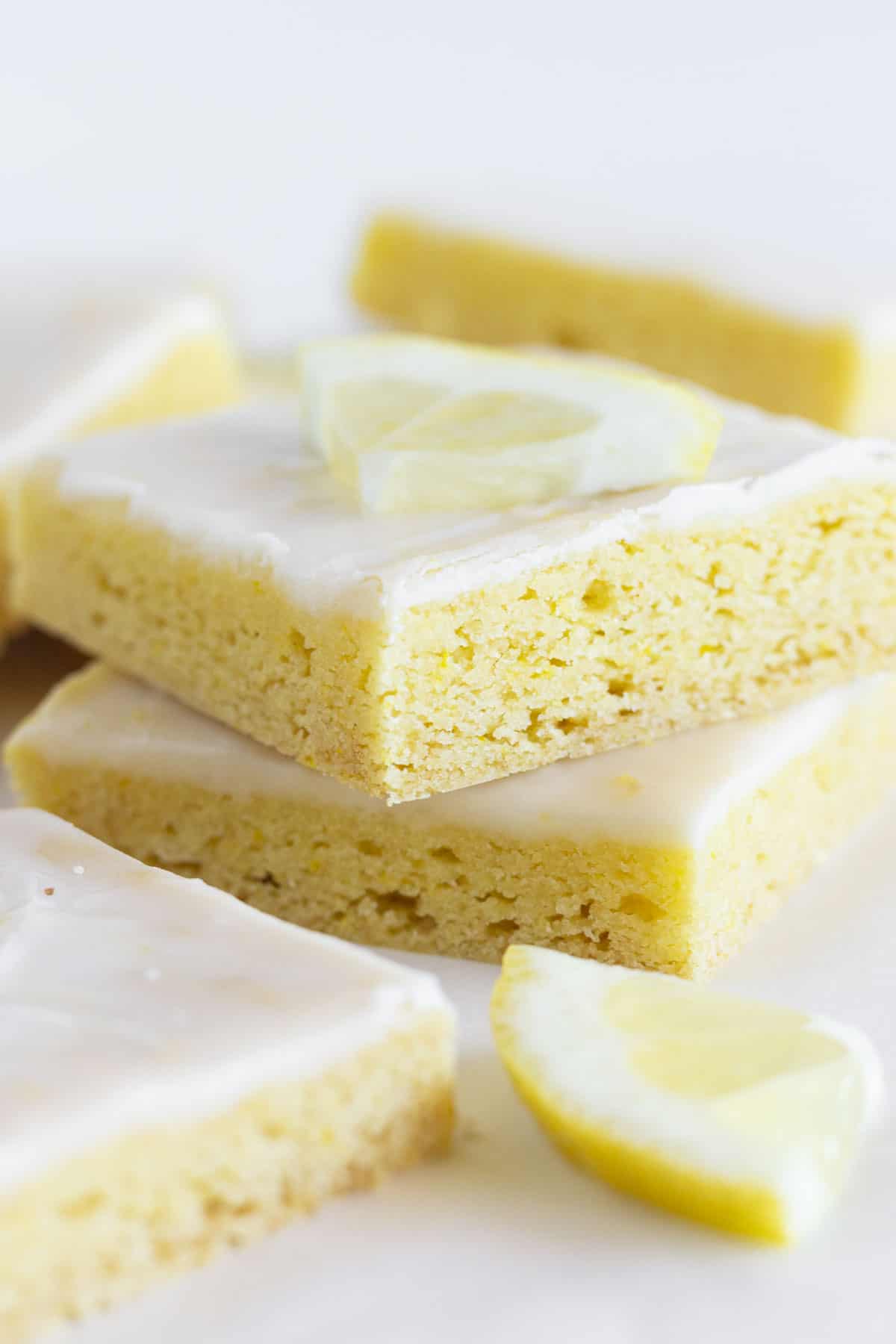 A stack of lemon cake mix cookie bars on a white tray.