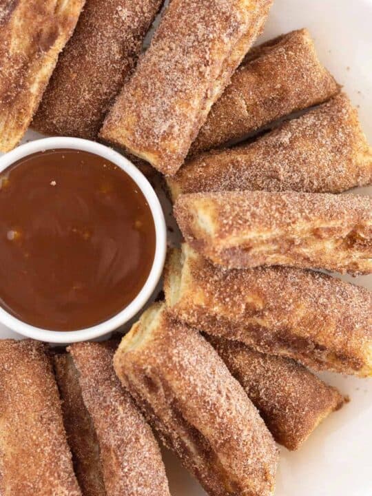 A plate of baked churros, served with salted caramel.
