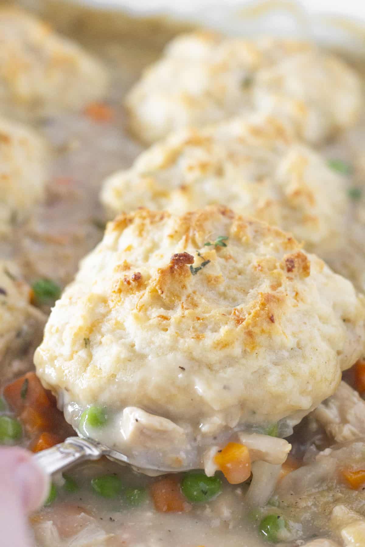 Serving Chicken and Biscuits Casserole with a spoon.