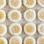 Lemon curd cookies on a sheet pan and sprinkled with powdered sugar.