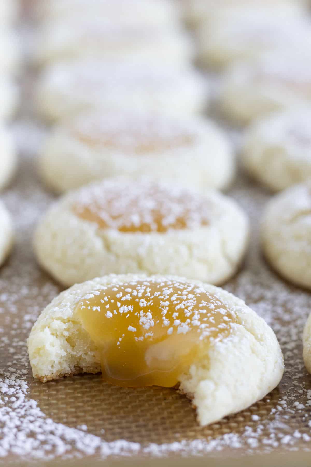 Finished lemon curd cookies on a baking sheet.