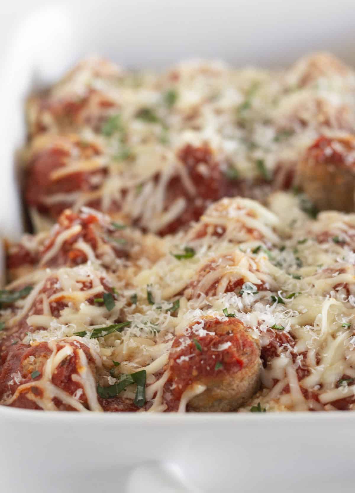 Finished meatball sub casserole in a white baking dish.