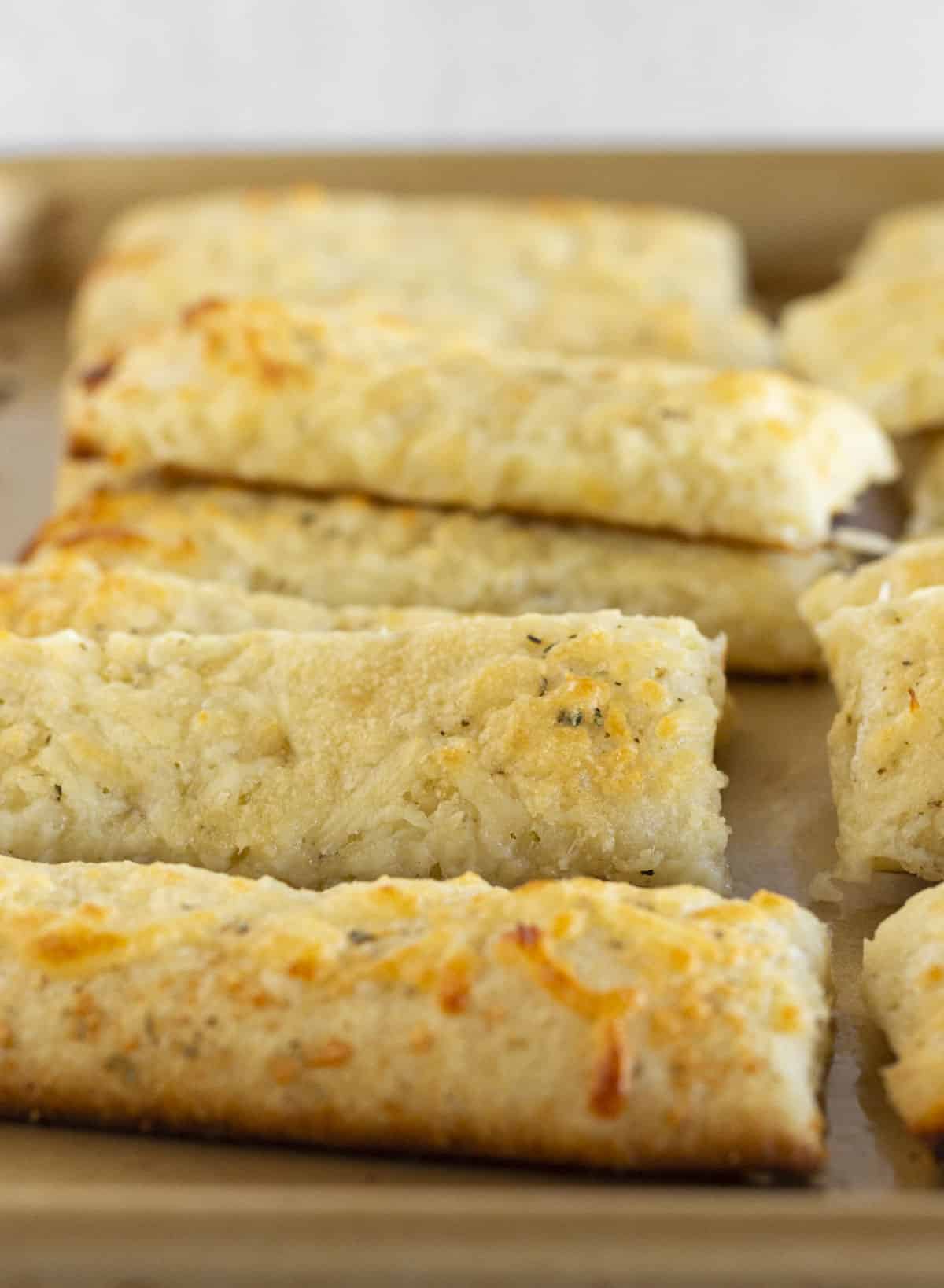 Cheesy breadsticks on a baking sheet.